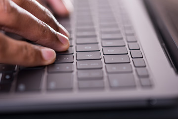 fingers typing on a laptop computer