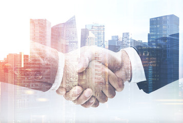 two businessmen shake hands in a city close up