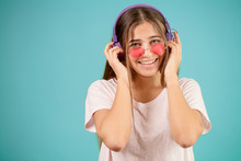 Cheerful Teenage With Grey Eyes Touching Her Headphones On Her Head
