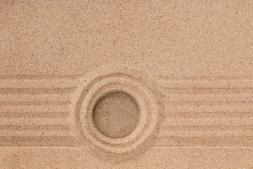 Wall Mural - White stone lies in the center of a circle of sand. Summer concept.