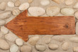 © alekleks - Classical wooden arrow and white stones on the sand.