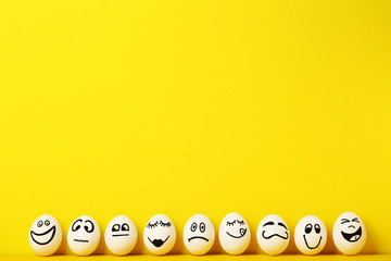 eggs with funny faces on yellow background