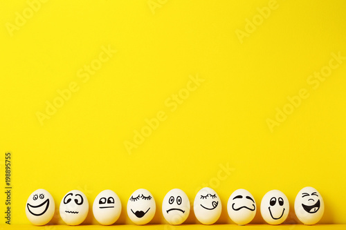 Fotografía Eggs with funny faces on yellow background