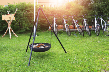 Fireplace at camping site. Group of frineds parked bikes near tree. Travel and sport activity outdoors