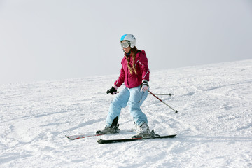 Poster - Woman skiing on piste at snowy resort. Winter vacation