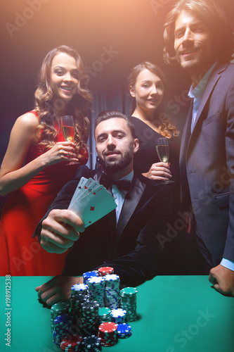 фотография concentrated men and women playing poker in casino