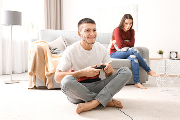 Canvas Print - Angry woman looking at man who is playing video game at home