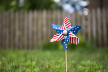 A Close Up Bokeh Photo Of A Pinwheel With The American Flag Stars And Strips Pattern.