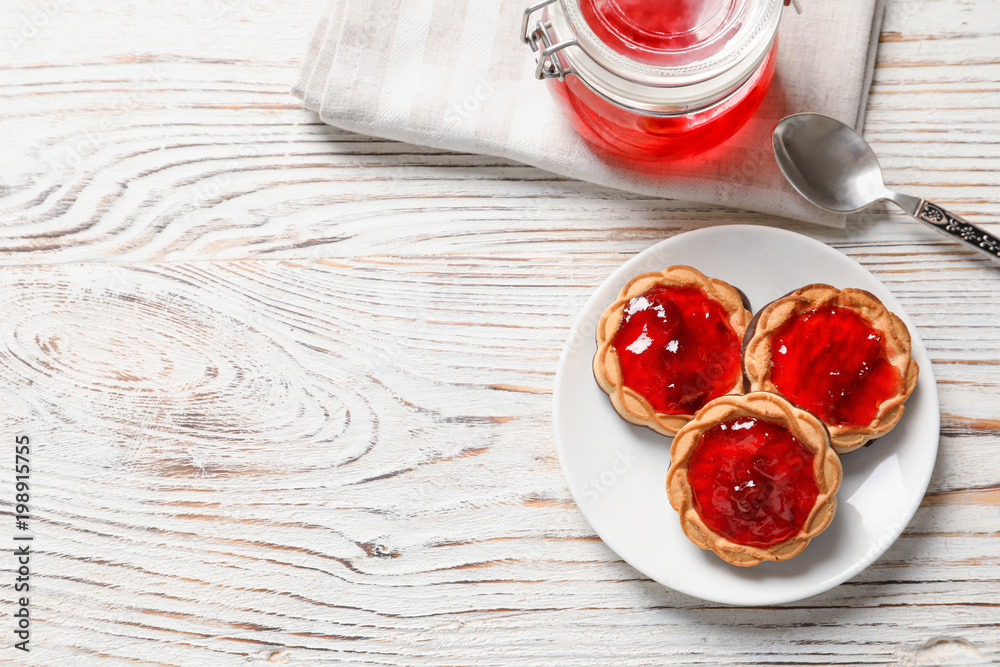 Tasty cookies with jam on plate