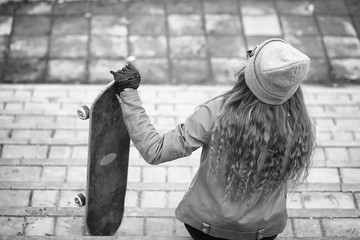 A young hipster girl is riding a skateboard. Girls girlfriends f