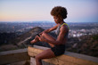 © Joshua Resnick - athletic african american woman using smartphone at runyon canyon while resting on bench at dusk