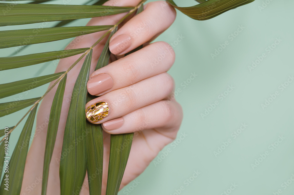 Valokuva Beautiful female hand with beige nail design