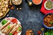 Turkish or arabic cuisine. Turkish food on dark stone background, top view with copy space for text. Kebab, baklava, imam bayildi, spices and nuts