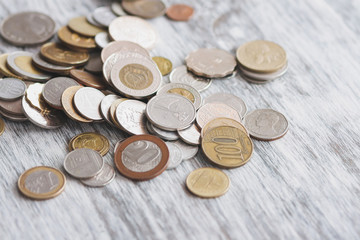 Different collector coins and piggy bank on the wooden background