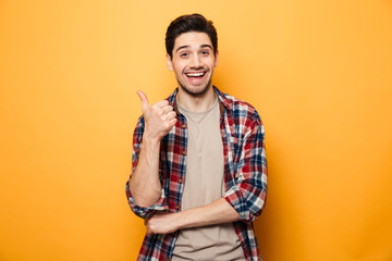 portrait of a smiling young man pointing finger away