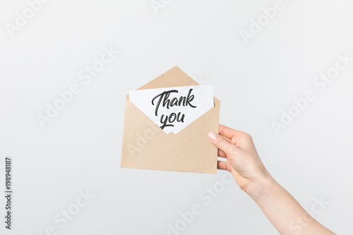 Fotografie, Obraz partial view of woman holding kraft envelope with thank you card isolated on whi