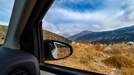 View of the mountain landscape from the car window on the road in Greece, Crete. Tourist trip by car.