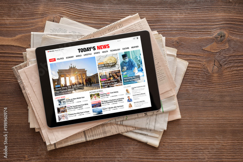 Cuadros en Lienzo Tablet with news website on stack of newspapers
