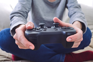 Wall Mural - man holding a joystick controllers while playing a video games at home