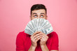 © Drobot Dean - Portrait of a cheerful young man holding money banknotes