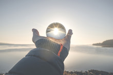 Hand Holding A Crystal Ball In The Winter Sunrise
