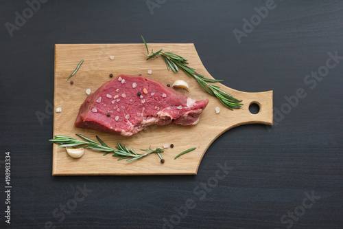Zdjęcie XXL surowy stek wołowy z rozmarynem i czosnkiem na deski do krojenia