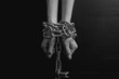 Black and white minimalistic image. women's hands chained close-up on a black background, toned to a retro film