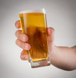 Hand hold glass of beer on the gray background
