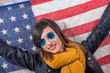 young brunette with blue sunglasses in front of  american flag