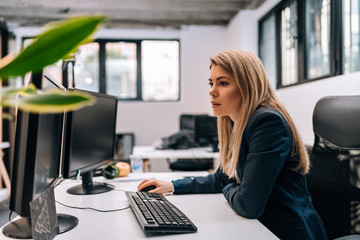 Serious blonde businesswoman working on a computer.