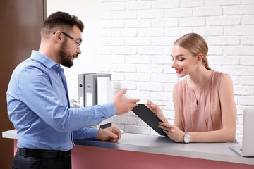 Canvas Print - Male receptionist with trainee at workplace