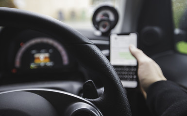 Driver on the phone whilst at the wheel of a car, texting and driving. 