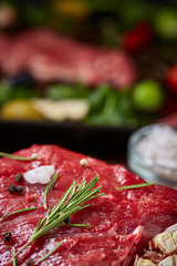 Wall Mural - Still life of raw beef meat with vegetables on wooden plate over vintage background, top view, selective focus