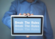 © andranik123 - Businessman holding Break The Rules word on a tablet screen.