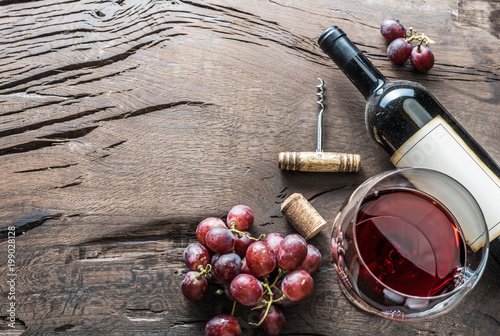 Fotomural Wine glass, wine bottle and grapes on wooden background