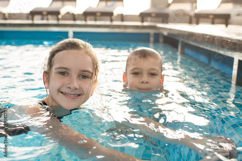 Portrait Of Positive Cute Kids With Wet Hair Sitting In Warm Water