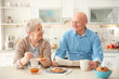 © New Africa - Elderly couple having breakfast in kitchen