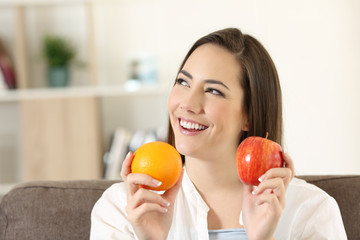 Wall Mural - Woman wondering about apple and orange