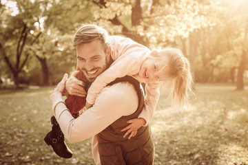 Wall Mural - Smiling father in autumn day with daughter.