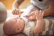 © Mladen - Mother rubs teeth of her little baby boy with gel. Close up.