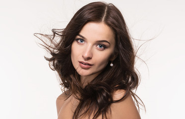 Portrait of a beautiful young girl with dark long hair and professional make-up on a white background.