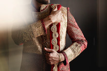 Strong Handsome Indian Groom Holds His Hands Over Wedding Suit