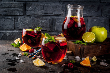 Wall Mural - Summer cold cocktail, fruit and berry red wine sangria with apple, lemon, oranges and raspberry. dark background, copy space