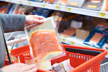 Wall Mural - Pack of salmon in hand at store