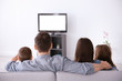 © Africa Studio - Family watching TV on sofa at home