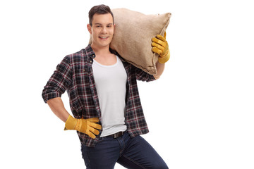 Wall Mural - Farmer holding a burlap sack and looking at the camera