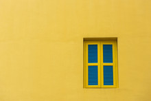 Closed Yellow And Blue Window On Yellow Wall