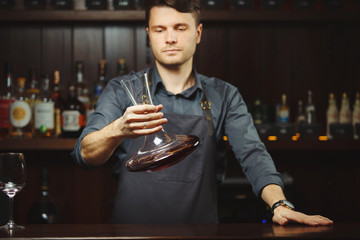 Wall Mural - Bartender decanting wine without disturbing the sediment