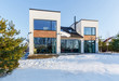 A modern house with large panoramic windows in the background of a snow-covered landscape