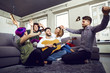 © Studio Romantic - Friends playing the guitar, sing fun indoors. Merry party of friends.